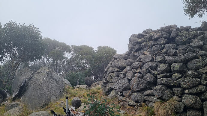 Inverted L antenna draped on the rock cairn to a stick at the top.