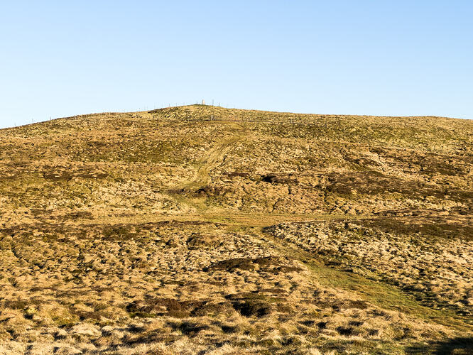 View of the summit of Earl's Seat with grassy path in foreground